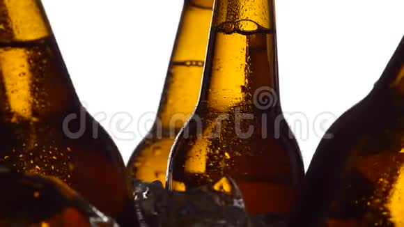 瓶装啤酒它们在冰上旋转白色背景剪影关门视频的预览图