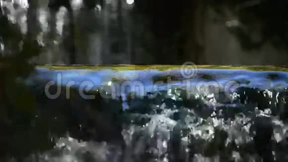 在阳光明媚的一天一条河流的纯净水山在瀑布中落下视频的预览图