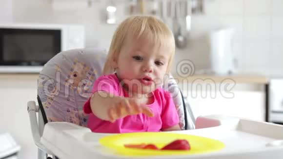 坐在高椅上吃草莓的小女孩视频的预览图