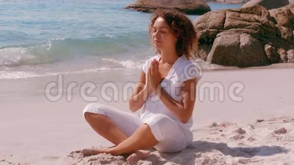 专注的女人在海边做瑜伽视频的预览图