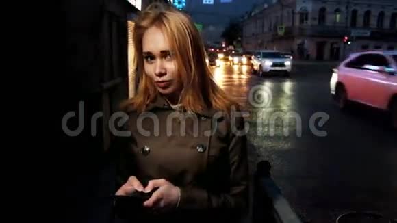 晚上城市里快乐的女人在背景上移动汽车调调镜头视频的预览图