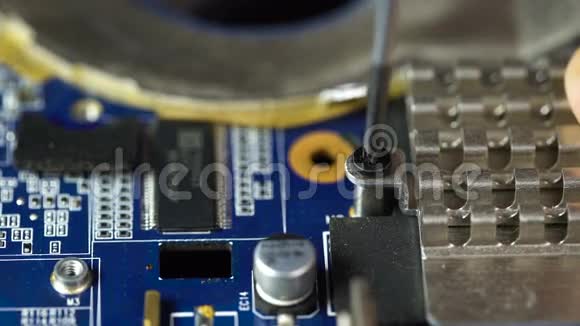 手拿镊子夹在笔记本电脑螺丝上手拿螺丝刀正在安装或修理电脑部件视频的预览图