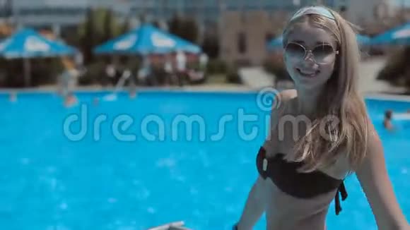 站在游泳池附近的美丽的金发女郎视频的预览图