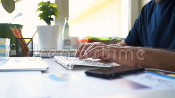 商人在键盘上打字工作与智能手机和笔记本电脑视频的预览图