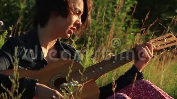 快乐的女孩在户外弹吉他视频的预览图