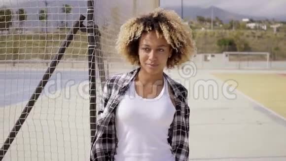有滑板的年轻女子在球场上摆姿势视频的预览图