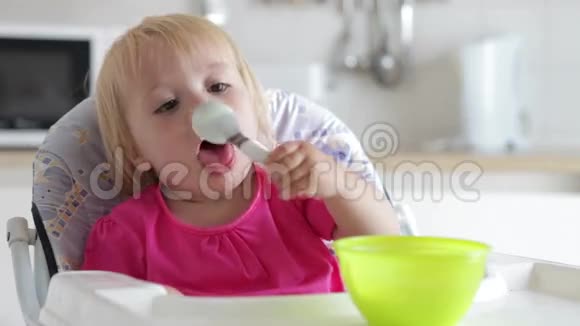 年轻女孩坐在高椅上吃酸奶视频的预览图