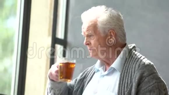 关心老人的白种人喝茶看窗视频的预览图