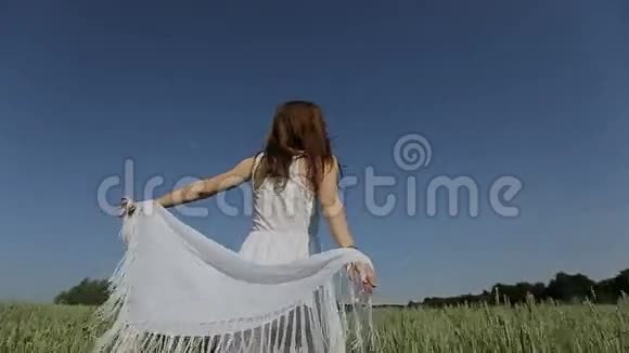 穿着白色连衣裙的漂亮女孩在野外玩得很开心慢动作快乐微笑的年轻女人享受大自然视频的预览图