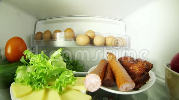 在冰箱里找食物的女人选择肉类还是蔬菜视频的预览图