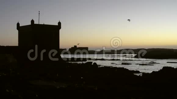 美丽的日落在海洋和堡垒的轮廓在前景视频的预览图