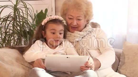 祖母和孙女使用平板电脑视频的预览图