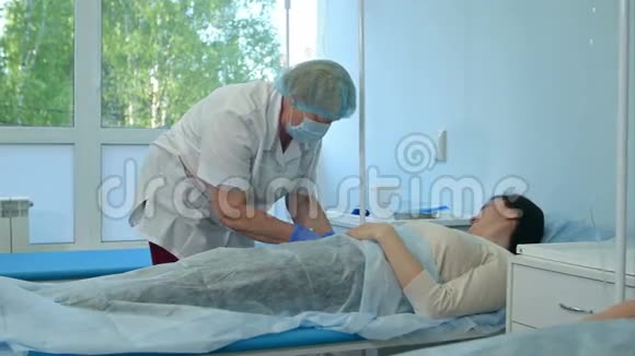 带手套和口罩的护士把女病人送到医院病房视频的预览图