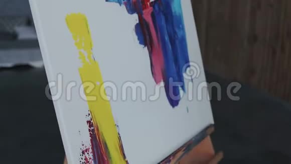 现代绘画女性手的特写镜头在画布上用铲子做大的黄色涂片这就是视频的预览图