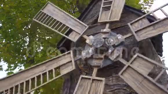 磨坊在风中转动在秋树的背景上合上旧磨坊木磨坊历史遗产视频的预览图