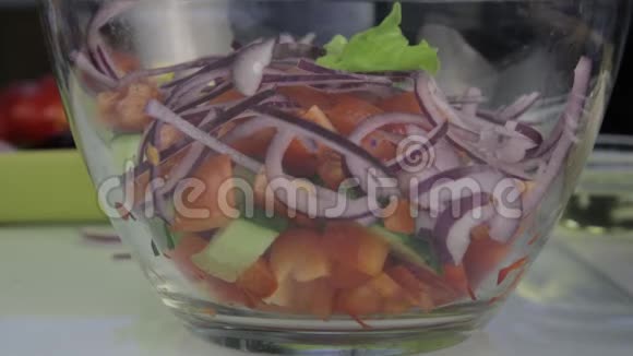 女人做素食低热量希腊沙拉把蔬菜放在碗里视频的预览图