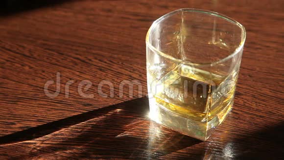 威士忌在桌子上男人的手拿着一个玻璃高清视频的预览图