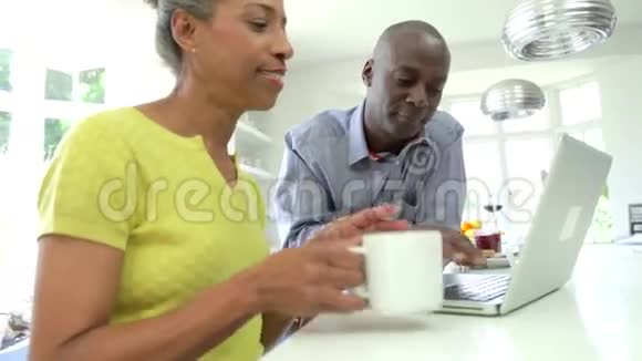 成熟的非裔美国夫妇在家使用笔记本电脑视频的预览图