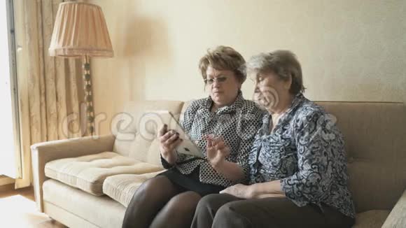 老妇人和她的朋友在看照片视频的预览图