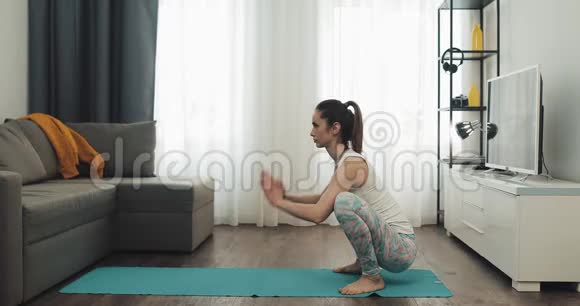 在家做瑜伽的年轻女人健康和运动的生活方式视频的预览图