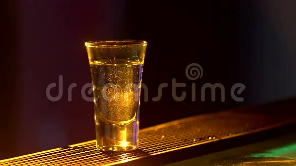 酒保正在制作鸡尾酒并加入三种不同的液体在酒吧柜台的边缘拍摄关闭背光视频的预览图
