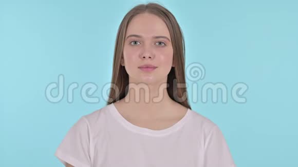 微笑美丽的年轻女子的肖像蓝色背景视频的预览图