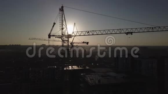 日落时的建筑工地建筑物附近建筑起重机的剪影视频的预览图