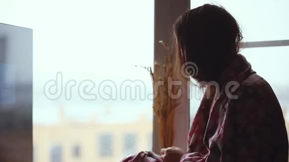 沮丧悲伤的女人坐在窗台上喝茶体贴地看着窗户1920x1080视频的预览图