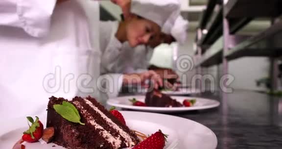 厨师团队用薄荷叶和草莓装饰甜点盘视频的预览图