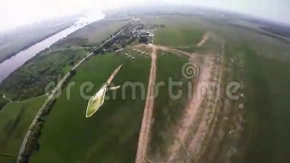 专业的跳伞运动员在绿色的田野上飞翔阳光明媚景观大自然视频的预览图