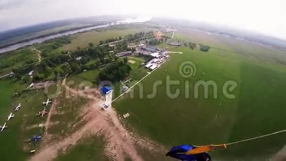 专业跳伞运动员登陆绿野草地晴天极限运动视频的预览图