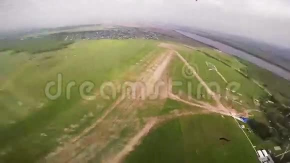 专业的跳伞运动员在农村绿色的田野上空飞翔晴天视频的预览图