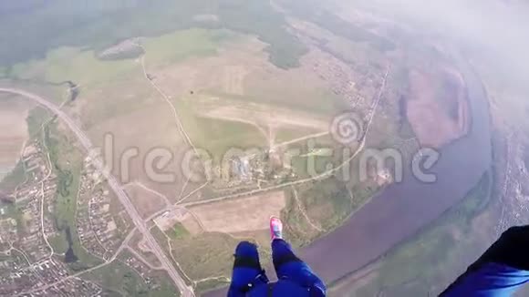 专业的跳伞运动员在绿色的平地上飞行夏天降落伞蓝色西装视频的预览图