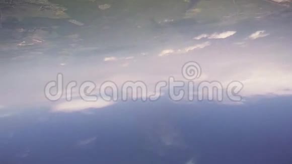 专业的跳伞运动员在绿色的田野上在蓝色的多云天空中飞行夏天航班视频的预览图