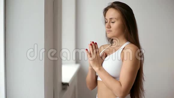 有魅力的年轻女人在室内做瑜伽视频的预览图