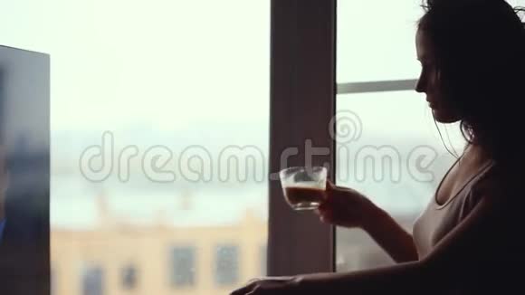 很胖的女人一边喝咖啡一边用手机看窗户1920x1080视频的预览图