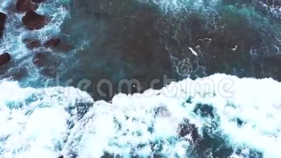 海洋波浪撞击岩石海岸线的抽象鸟瞰图视频的预览图