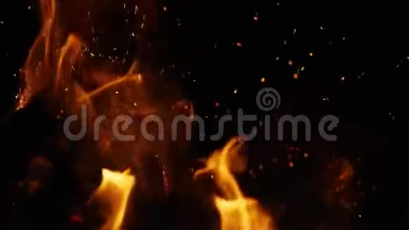 来自明亮燃烧的温暖的黑色背景的黑暗中的火花视频的预览图