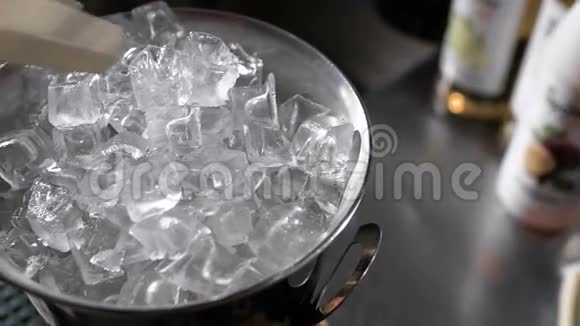 酒保用钳子拿出冰块来做鸡尾酒金属冰桶视频的预览图