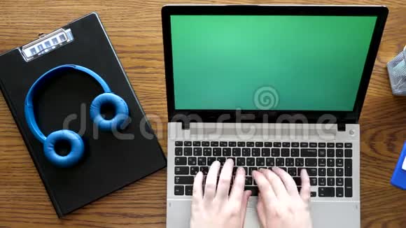 顶视图手在带有绿色屏幕的笔记本电脑上打字视频的预览图