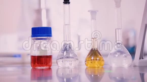 实验室桌上装有不同颜色液体的烧瓶和烧杯视频的预览图