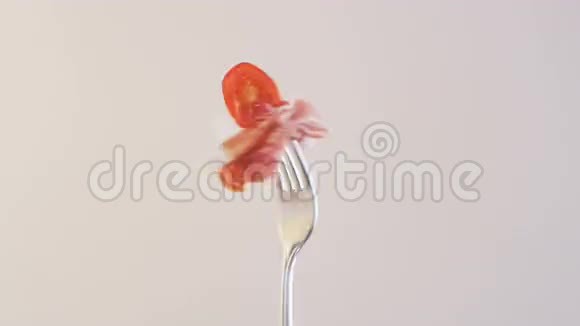 杏仁背景下火腿和鸡尾酒番茄旋转叉子视频的预览图