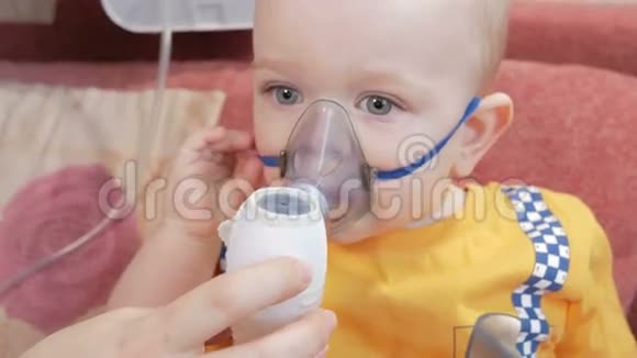 妈妈拿着口罩对着婴儿吸入器在家里吸药治疗气道炎症视频的预览图