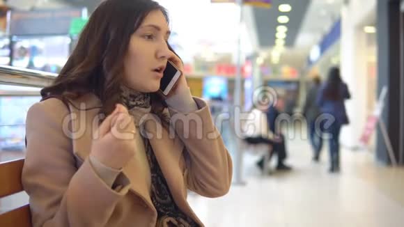 一个购物中心的年轻女子打电话视频的预览图