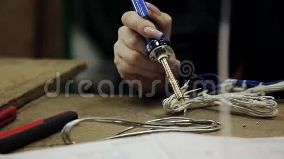在修理实验室里的女孩把电缆焊到连接器上视频的预览图