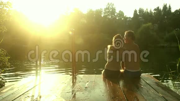 一对恋爱中的情侣坐在河坞里自拍接吻视频的预览图