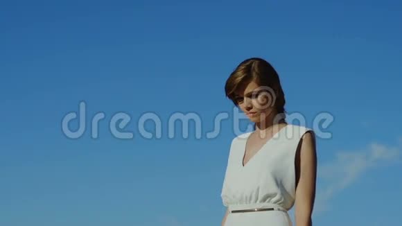 穿着裙子的女人走在与世隔绝的蓝天上视频的预览图