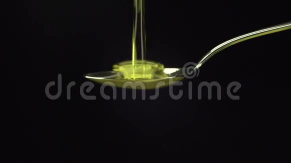 橄榄油倒在黑底的勺子上视频的预览图