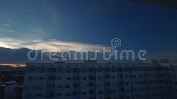 城市建筑上方黑蓝云天的橙色日落视频的预览图