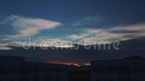 城市建筑上方黑蓝云天的橙色日落视频的预览图